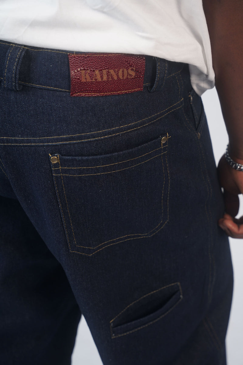 Close-up of the back pocket of the indigo jeans showing the red KAINOS tab