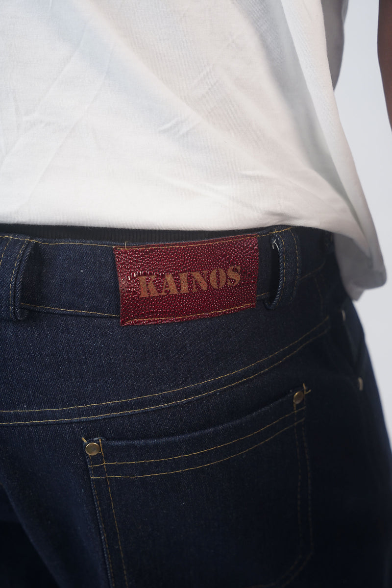 Close-up of the denim shorts waistband showing the red KAINOS tab