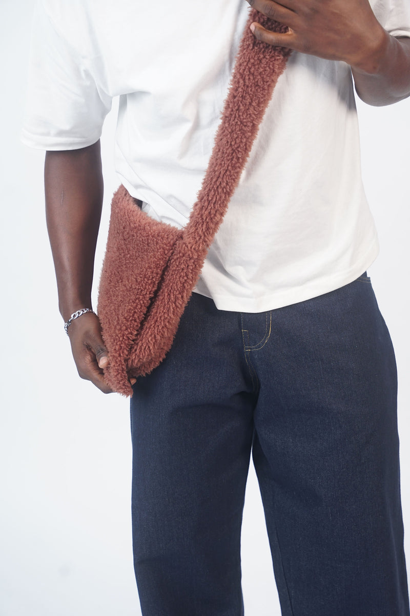 Model carrying the mocha brown shoulder bag across the body with a white T-shirt and navy trousers