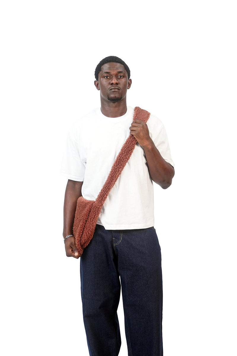 Model holding the mocha brown shoulder bag by its strap