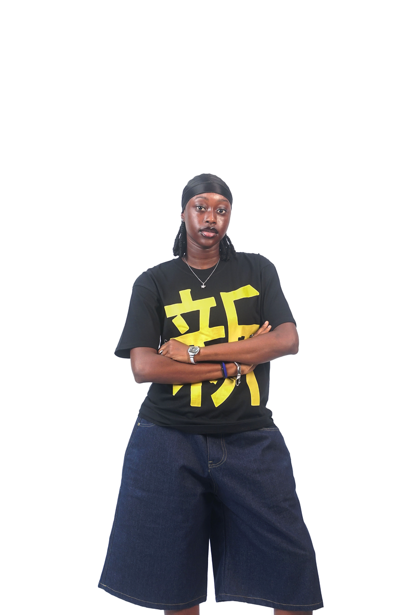 Model wearing the black T-shirt with the yellow Japanese character and navy denim shorts