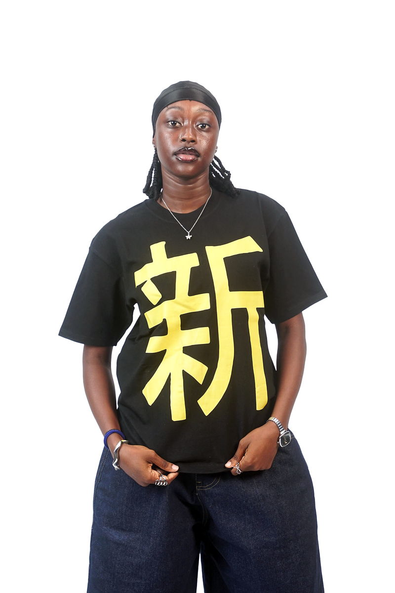Model wearing the black T-shirt with the yellow Japanese character and navy baggy jeans