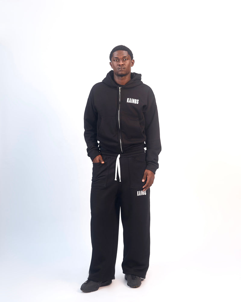 Model wearing the black zip-up hoodie with matching black wide-leg sweatpants