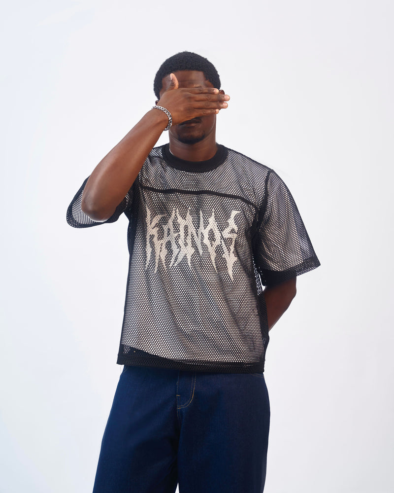 Model wearing the black mesh KAINOS T-shirt with navy jeans
