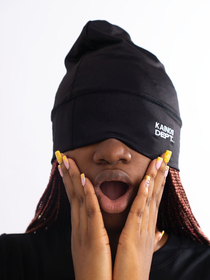 Model wearing a black KAINOS DEPT. beanie pulled down over the eyes